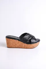 Sandalia negra de cuero con plataforma de corcho, diseño cruzado y taco de 6.5 cm.