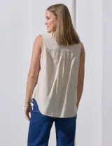 Camisa sin mangas de lino a rayas verticales azules y blancas, con cuello con solapa, escote en V, abertura central con botones y bolsillo en el pecho.