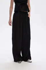 Pantalón negro de viscosa, corte ancho y tiro alto, con elástico en la cintura y bolsillos laterales.