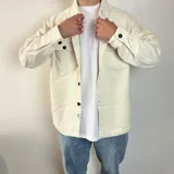 Sobrecamisa color marrón claro de pana con cuello clásico, cierre abotonado, dos bolsillos de parche con solapa abotonada en el pecho y corte recto.