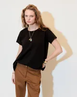 Remera negra de jersey flama 100% algodón, de línea A y fit relajado, con escote redondo a la base, manga corta y recortes a los costados.