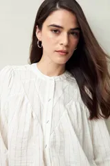 Camisa celeste a rayas verticales, de corte amplio, cuello mao y mangas 3/4 abullonadas.