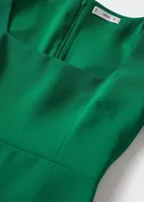 Vestido corto entallado color verde esmeralda, con escote cuadrado, mangas largas y cierre de cremallera en la parte posterior.