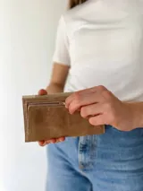 Billetera beige, crema y marrón con cierre de broche y monedero externo.