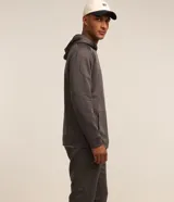Buzo deportivo gris con capucha ajustable, manga larga ajustada, bolsillo canguro, detalles en recortes y textura.