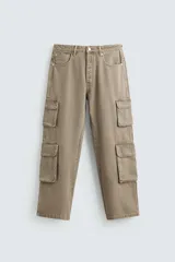 Pantalón de denim color beige, corte relaxed fit, con bolsillos laterales tipo cargo con solapa y cierre de botón. Cierre frontal con botón y cremallera.