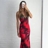 Vestido largo de fiesta con breteles finos, escote en V con detalle de encaje negro y estampado tie-dye en tonos rojo y negro.