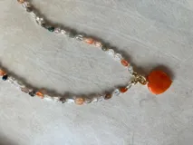 Collar de cuentas de colores con dije de corazón.