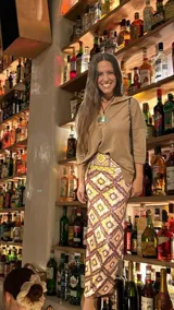 Falda midi de terciopelo elastizada con estampado geométrico en tonos marrones, amarillos y naranjas. Tiene un tajo lateral y elástico en la cintura.