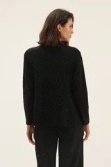 Blazer negro con estampado de lunares blancos, de corte recto y solapas clásicas.