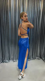 Vestido largo de fiesta azul eléctrico con lentejuelas, espalda descubierta y tiritas cruzadas.