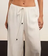 Pantalón de playa de lino y viscosa color blanco, con rayas laterales a contratono, cintura elastizada y lazo ajustable.