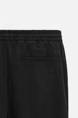Pantalón negro de corte recto con cintura elástica ajustable con cordón, bolsillos laterales y traseros.