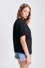 Remera negra de manga corta con nudo en el hombro.