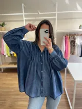 Camisa azul de algodón, corte amplio, con cuello mao, mangas largas con puños abotonados y cierre frontal con botones.