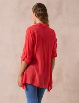 Camisa color beige claro, de corte recto y mangas 3/4 con botón para sujetar.