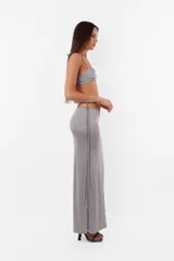 Conjunto de top y short color beige confeccionado en tela brillante. El top cuenta con arco metálico en el busto, tiras para atar en el hombro y ganchos lenceros en la espalda. El short es de tiro alto con cintura elastizada y bolsillos laterales.