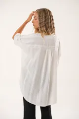 Camisa blanca con calados, escote en V, abotonada y manga 3/4.