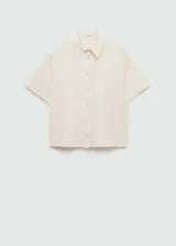 Camisa blanca de lino con cuello clásico, manga corta y cierre frontal con botones.