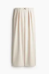 Pantalón sastre color crema de punto crepé con pinzas, tiro alto, cintura elástica, cinturón decorativo con hebilla de metal y piernas amplias rectas.