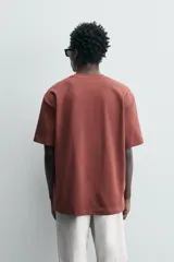 Camiseta blanca de algodón interlock con elasticidad, corte recto, cuello redondo y mangas cortas.