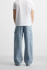 Pantalón de jean negro, corte relaxed fit, con bolsillos frontales y traseros tipo parche, tira multifunción y bolsillo tipo parche en las piernas. Tiene efecto lavado y cierre frontal con cremallera y botón.