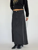 Pollera larga de denim color tostado con detalles de costura blanca y corte asimétrico.