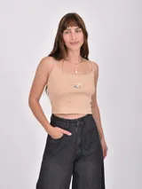 Musculosa corta color beige con breteles finos y estampado de una sombrilla de playa y una reposera.