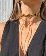 Gargantilla de cuero marrón con doble tira y dijes de flores espejadas.