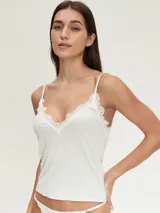 Conjunto de ropa interior gris melange, compuesto por musculosa de breteles finos y tanga con detalles de encaje blanco.