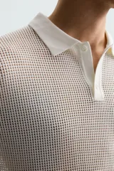 Polo blanco de punto tejido con estructura calada, corte regular fit, cuello solapa con abertura frontal y manga corta.