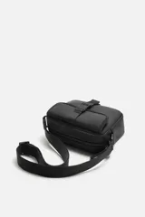 Bandolera negra de acabado engomado, con compartimento principal con cierre de cremallera y bolsillo interior con cremallera. Bolsillo frontal con cierre de hebilla de liberación rápida. Asa de hombro ajustable y extraíble.