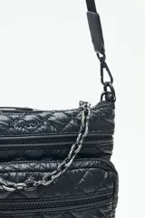 Cartera bandolera azul con diseño matelassé, cadena metálica decorativa y dos correas desmontables. Cuenta con cierre superior y múltiples bolsillos internos.