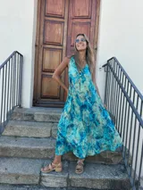 Vestido largo turquesa con estampado abstracto, corte al sesgo y escote en V tanto en la parte delantera como en la trasera.