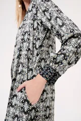 Camisa midi estampada en blanco y negro, con cuello mao y mangas largas.