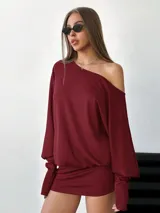 Vestido corto elastizado color bordó, asimétrico, con manga larga y hombro al descubierto.