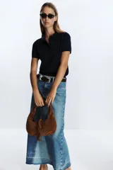 Bolso de hombro marrón de serraje con asa corta y flecos decorativos.