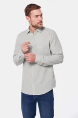 Camisa de lino color beige, de manga larga, con cuello clásico y bolsillo en el pecho.