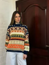 Sweater de lana merino con cuello redondo y diseño con motivos geométricos en tonos azul, marrón, naranja, verde y beige.