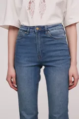 Pantalón de jean azul de corte recto, tiro alto y terminación desflecada.