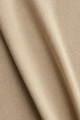 Musculosa de punto fino color beige, entallada, con escote en U en la parte delantera y trasera.