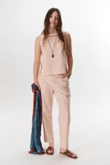 Top sin mangas color rosa pálido, con cuello redondo y vivos en color marrón oscuro en el cuello y a lo largo de las costuras laterales.