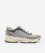 Championes dad sneaker grises con recortes en cuero sintético, cordones blancos y suela chunky de goma color crema.