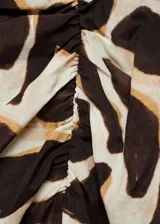 Falda midi de viscosa con estampado animal print en tonos marrones y beige. Diseño recto con abertura lateral y detalle drapeado en la cintura.