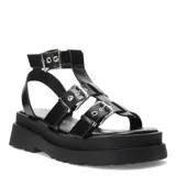 Sandalias bajas color beige con plataforma y tiras anchas con hebillas plateadas, estilo romano.