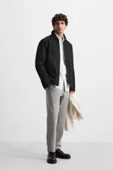 Pantalón slim fit negro confeccionado en tejido con elasticidad en ambas direcciones. Cuenta con bolsillos frontales y traseros de vivo con botón. Cierre frontal con cremallera y botón.