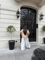 Pantalón sastrero negro de corte palazzo, con botón, pasacinto y pretina trasera con elástico.