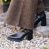 Bota corta negra de cuero vacuno, con taco de madera de 9 cm y plataforma delantera de 2 cm.