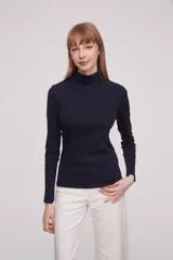 Polera de manga larga color blanco, ajustada al cuerpo y cuello alto.