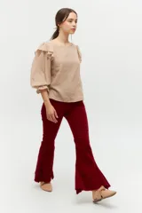 Blusa color rosa pálido de algodón con mangas cortas abullonadas y volados en el escote.